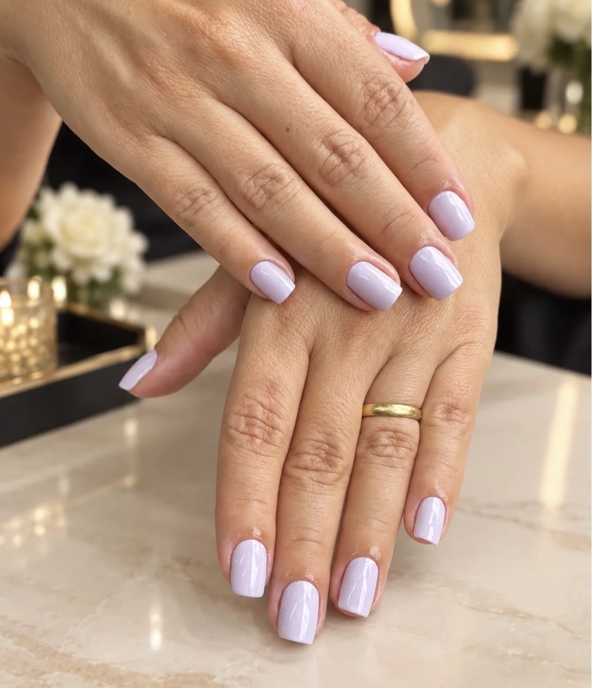 Unhas quadradas com esmalte lilás claro nas duas mãos